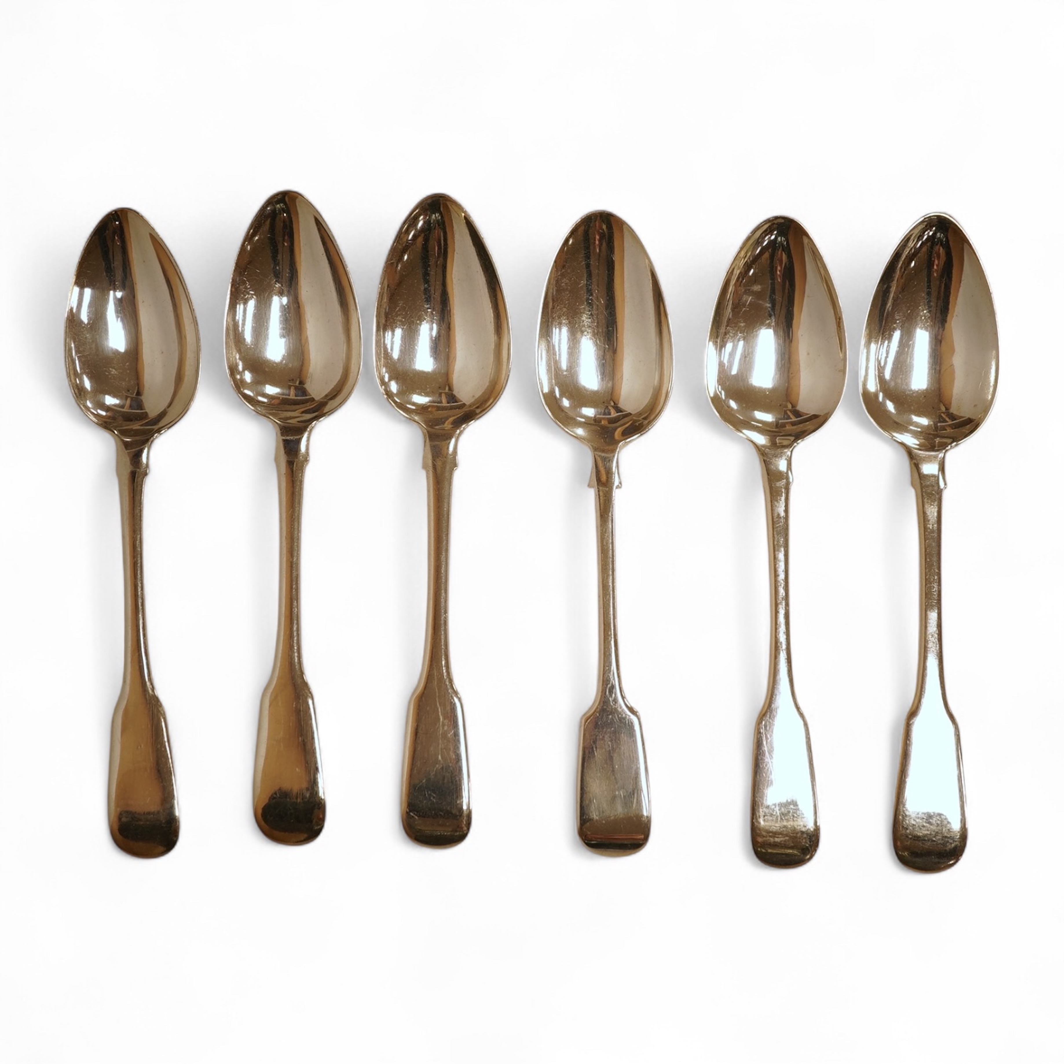 A matched set of six George III silver fiddle pattern dessert spoons, including five by William Eaton, London, 1815, 8oz.